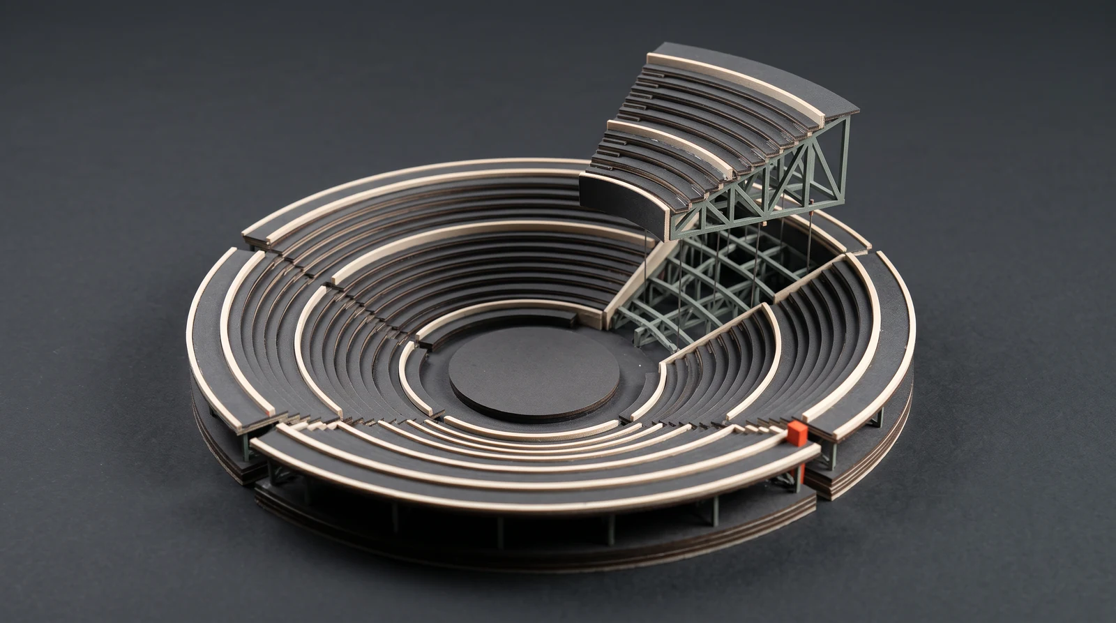 A miniature venue cutaway exposing the structural framework beneath its seating.